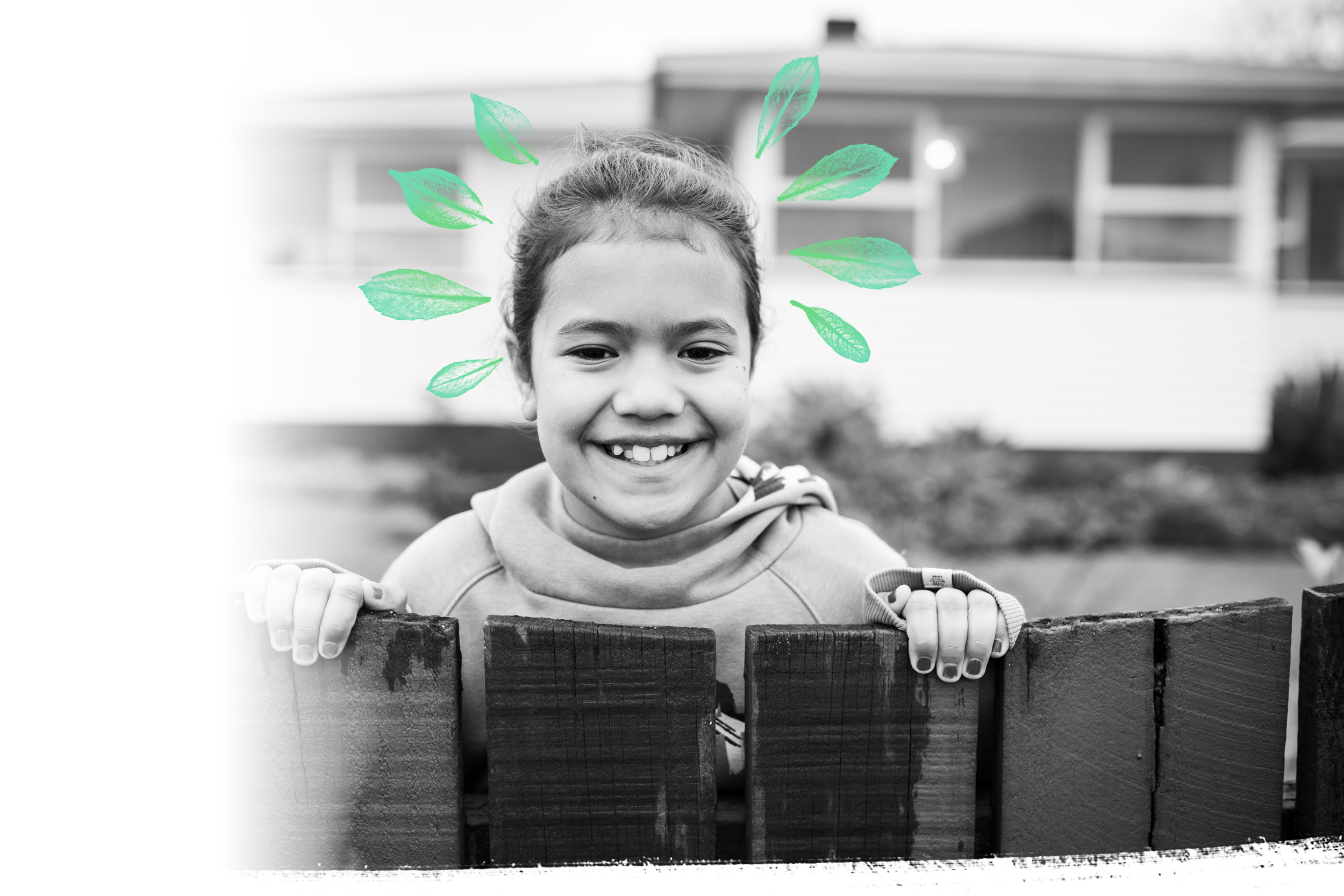Young girl smiling standing behind a fence
