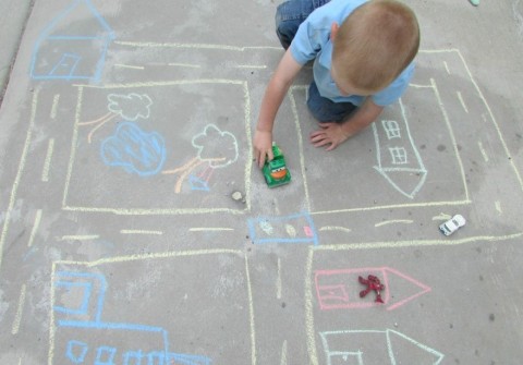 Child with neighbourhood chalk drawing